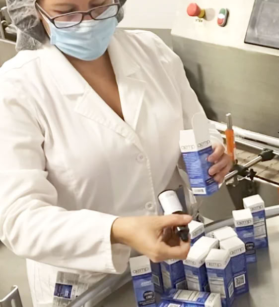 Quality control inspector examining finished beverage bottles at Nutrition Labs in Clearwater Florida
