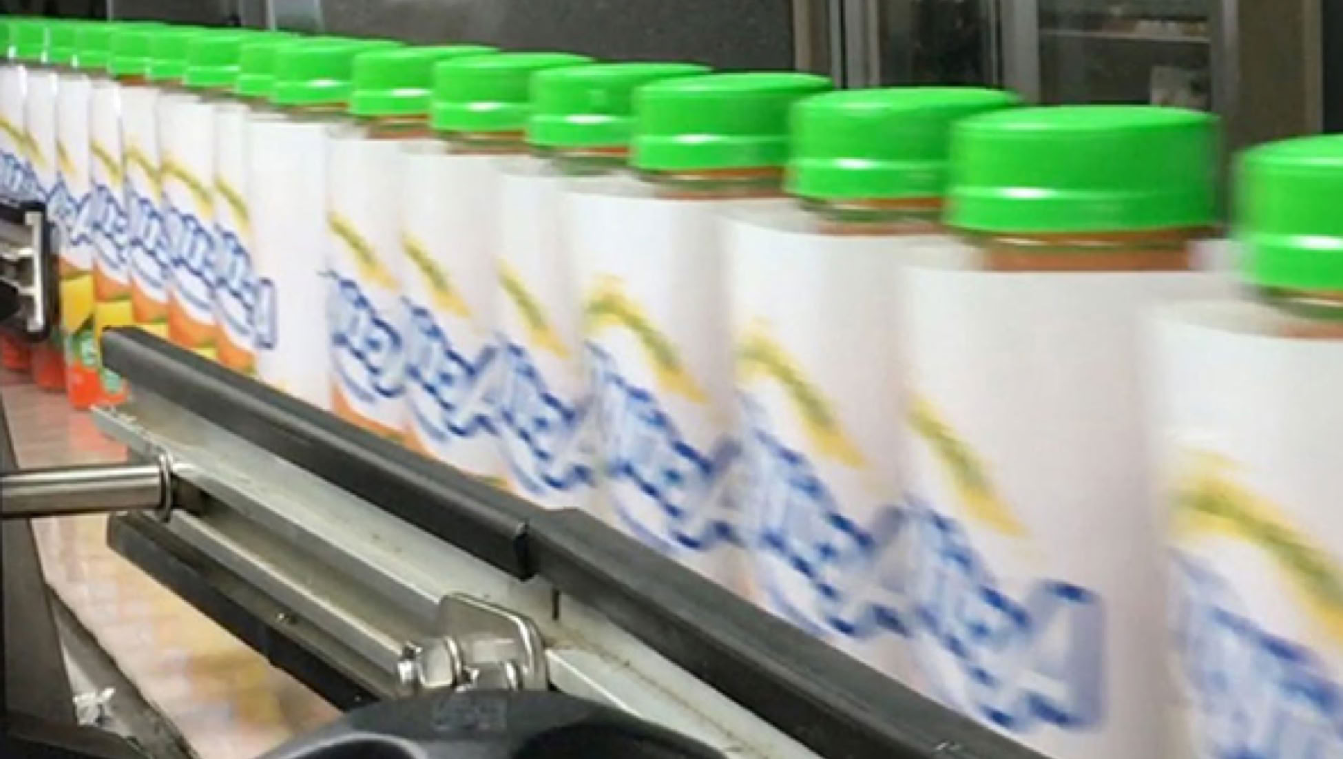 Protein drink bottles on conveyor at Nutrition Labs beverage co-packing facility in Clearwater, Florida